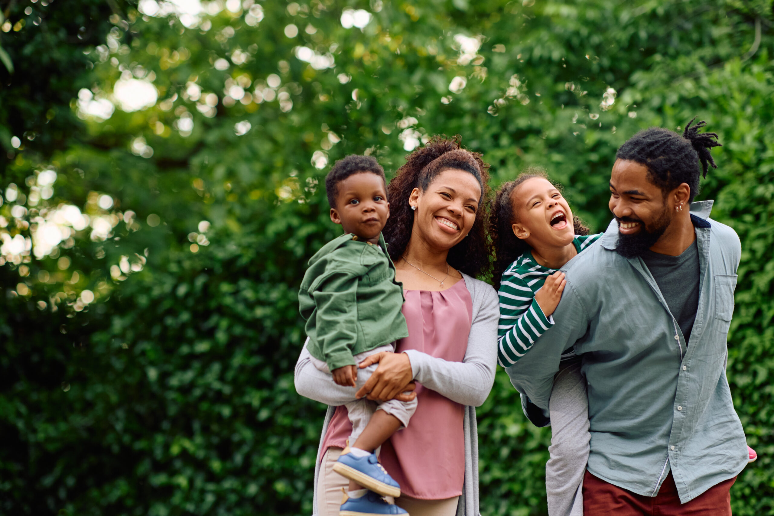 Cheerful black family having fun in park.